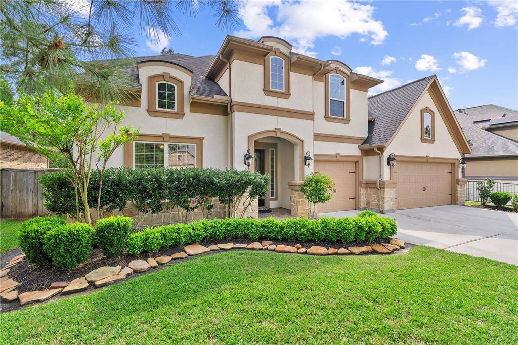 This beautiful two-story home features a classic exterior with a combination of stone and stucco finishes. The property boasts a manicured front yard with lush greenery and a spacious driveway leading to a three-car garage. Ideal for family living.
