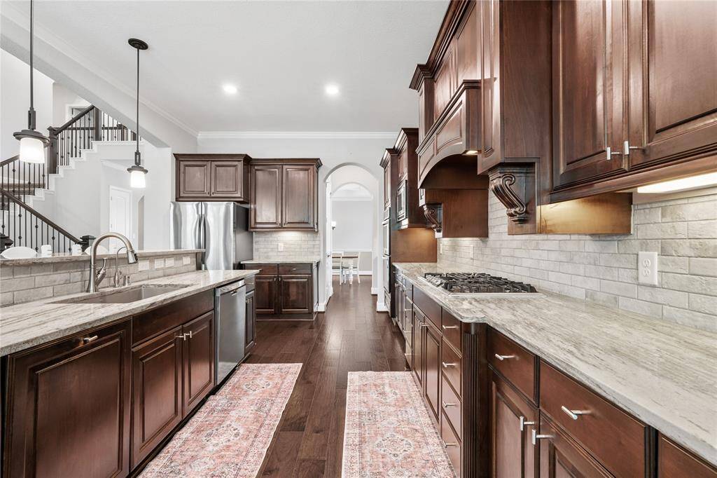Spacious layout with a central island, hardwood floors, and elegant pendant lighting, creating a warm and inviting atmosphere.