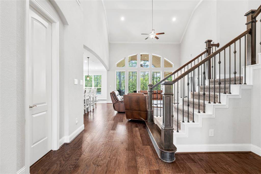 Bright, open entry with high ceilings and large windows, allowing natural light to flood in. Gorgeous staircase leads to upstairs living space.