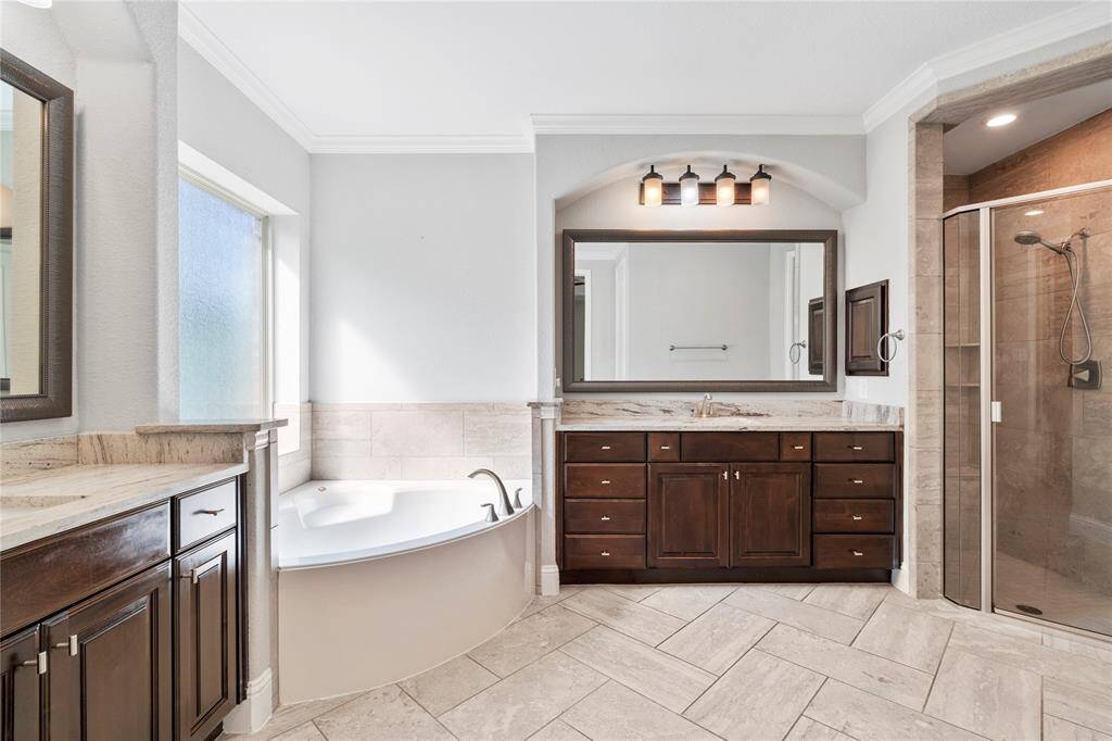 Luxurious soaking tub, two large vanities with ample storage, and walk-in closet.