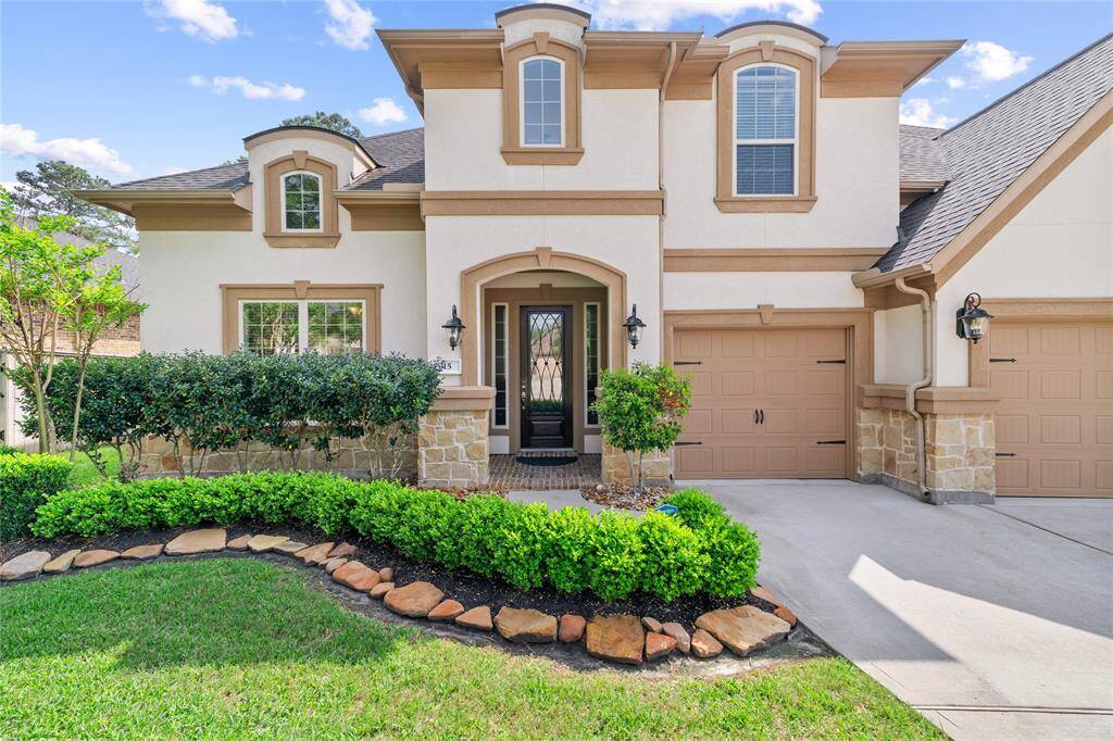 This home features an arched entrance and stone accents. The stone-bordered flowerbed welcomes guests and provides great curb appeal.