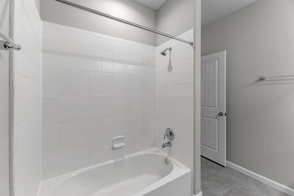 View of the tiled shower in the full bathroom