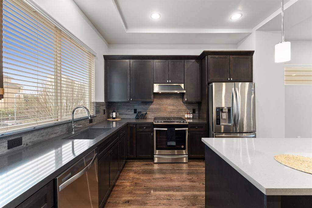 Modern kitchen with sleek stainless steel appliances, including a refrigerator that stays.