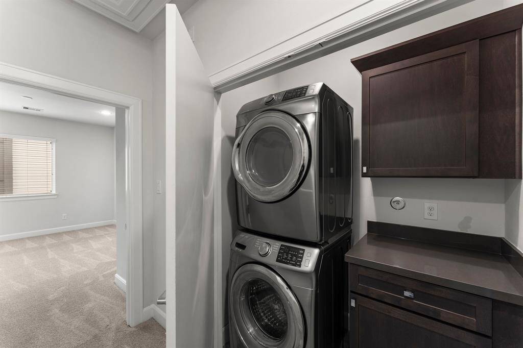 Laundry area with a stacked washer and dryer that stay with the home.