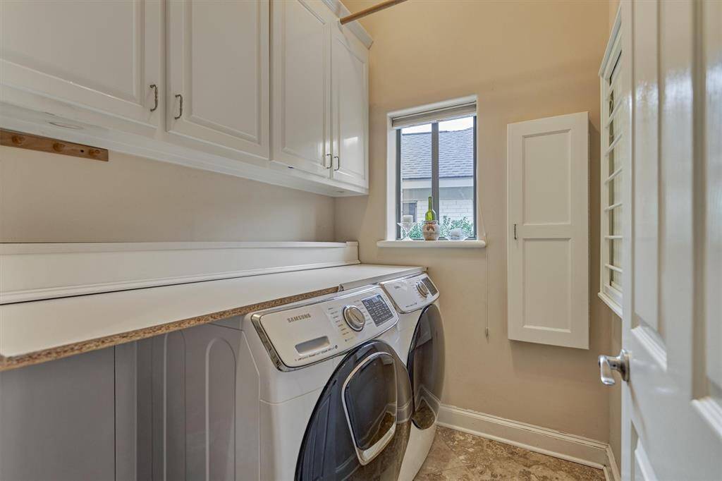 The laundry room has a folding counter, storage cabinets and drying rack.