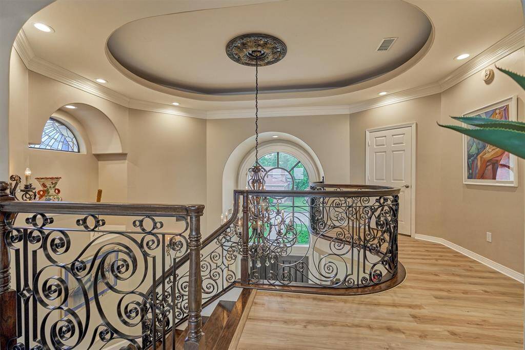 Upstairs, the intricate railing detail, paired with the ceiling's design, highlights the home's elegant and stylish design.