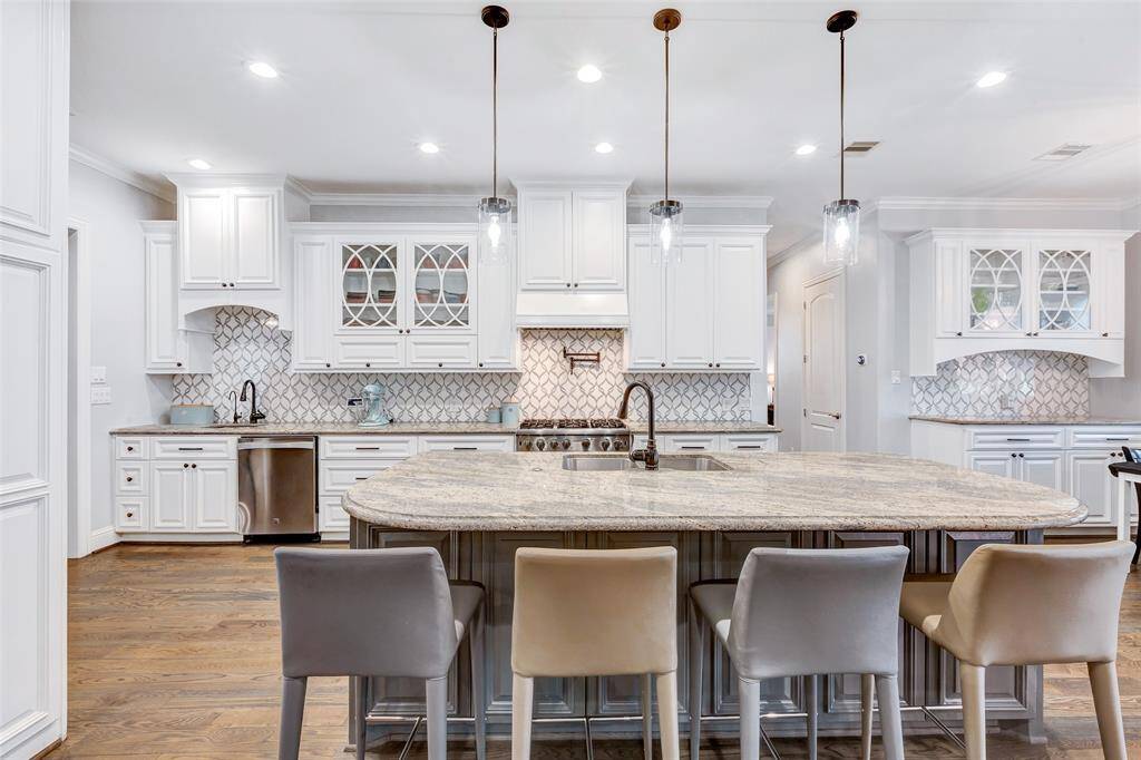 Beautifully designed, this kitchen will meet the demands of any chef with its abundant space for food preparation and storage while including a commercial refrigerator and freezer, two dishwashers, two sinks, Viking oven/range, and an additional oven on the island