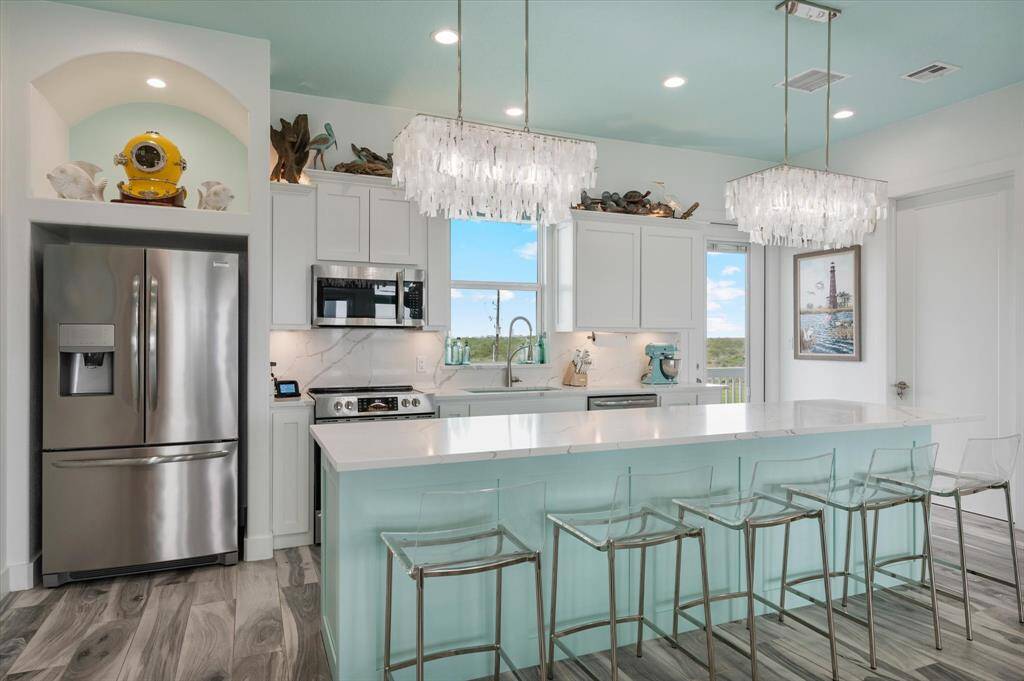 Well equipped kitchen with a large island with gorgeous pendant lighting. Refrigerator included