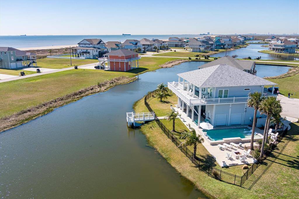 View of the home, lot, pond and beach