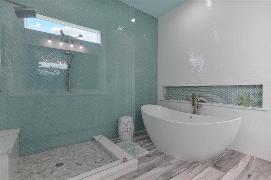 Primary bathroom. Notice both walls are completely tiled to the ceiling and the shower window for natural light