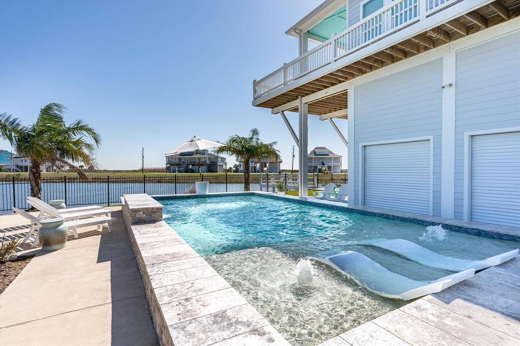 View of the heated pool and the side garage doors