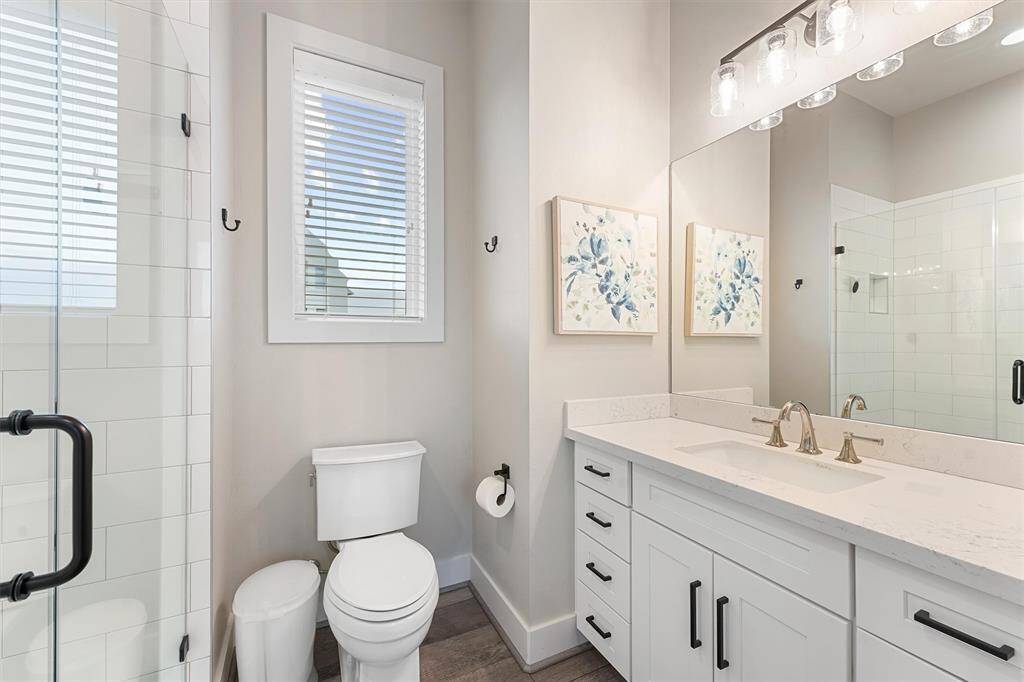 This bright and comfortable guest bedroom offers plenty of space with two beds and large windows showcasing beautiful natural light. A perfect retreat for family or friends.