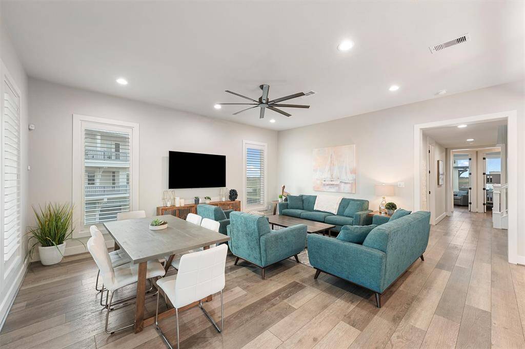 This gourmet kitchen is a chef's dream, featuring a spacious island with seating, stainless steel appliances, and sleek white cabinetry. The perfect combination of style and practicality, with easy access to outdoor dining.