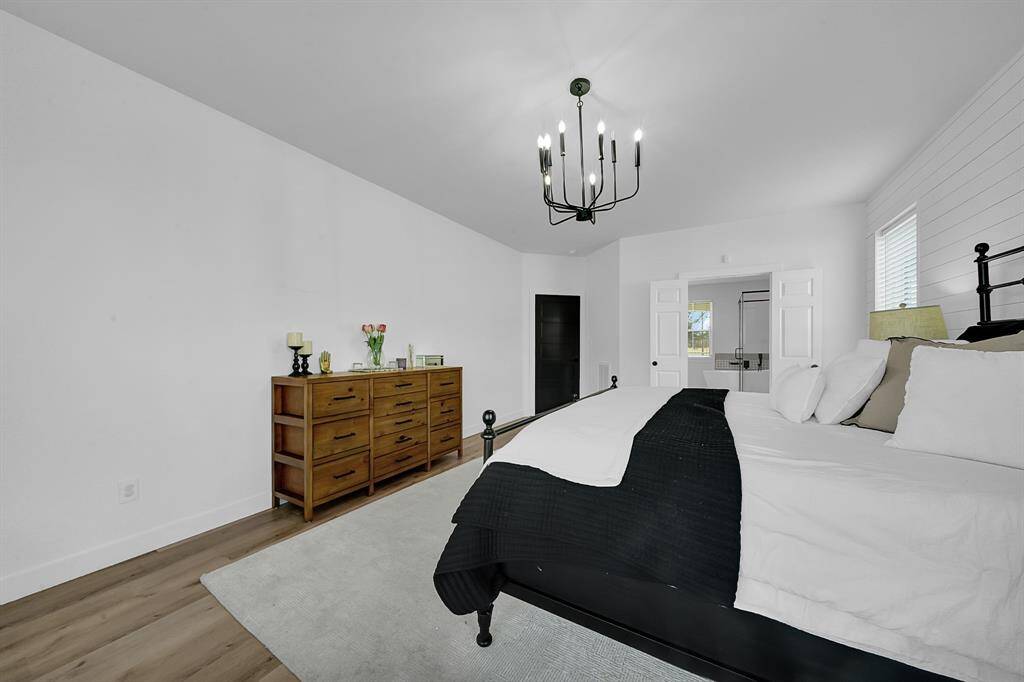 Discover your serene primary suite bathed in natural light, complete with a cozy sitting nook and picturesque window views.