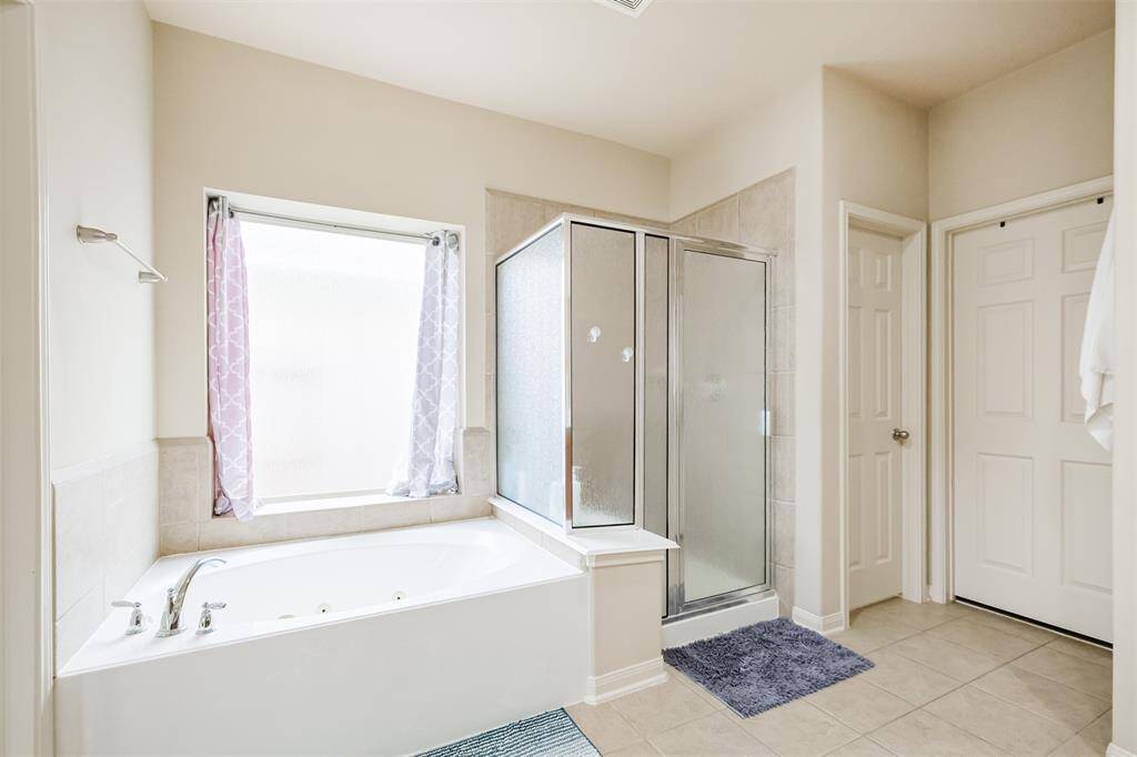 A primary bath with a jetted soaking tub and a sleek separate shower.