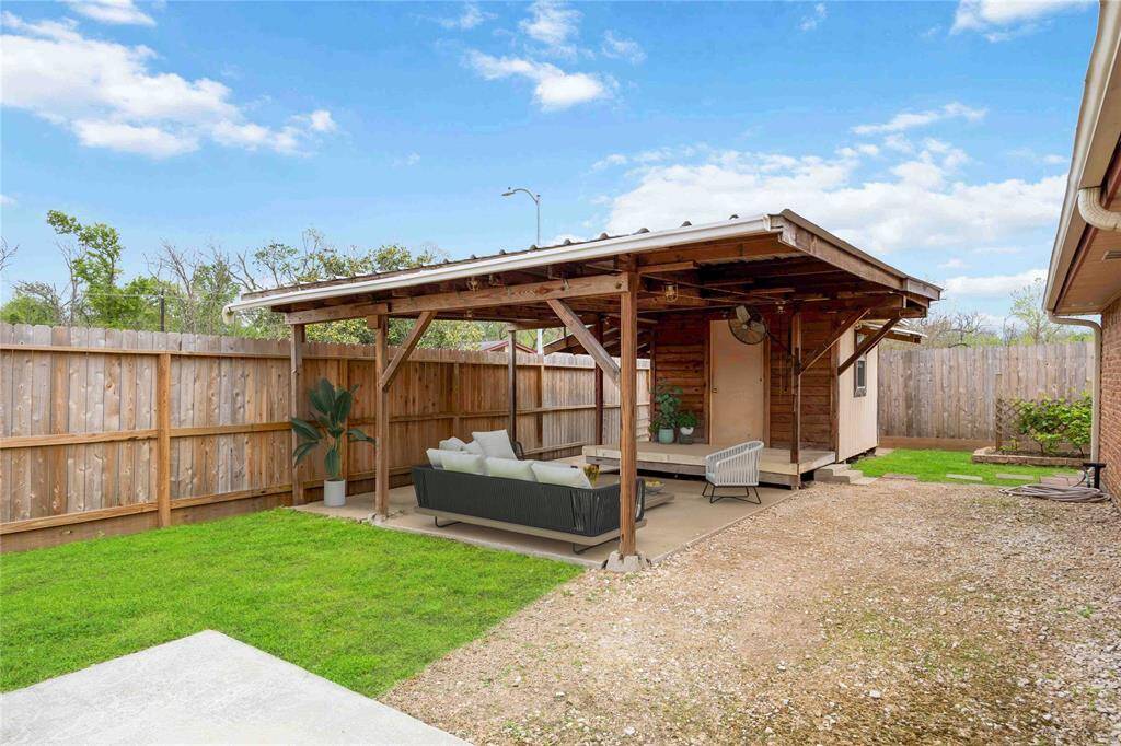 Covered patio with extra insulated storage room. The room can easily be converted to an extra room with a mini-split/AC unit installed. Virtually staged patio furniture.