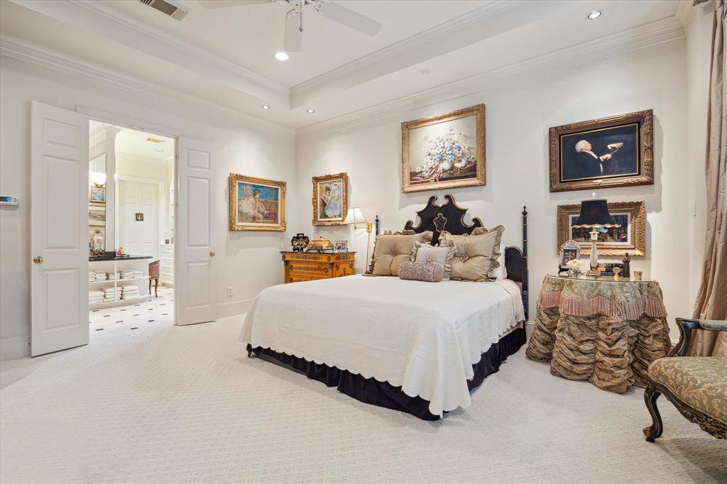 Photo features the coveted primary suite down fully furnished with views of the luxurious bath from the bifold doors.