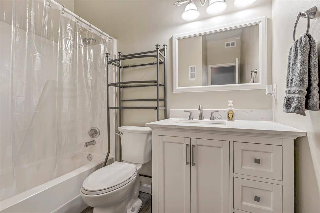 This secondary bathroom, located along the hallway and behind the laundry room, features a convenient tub and shower combo, offering both comfort and functionality.