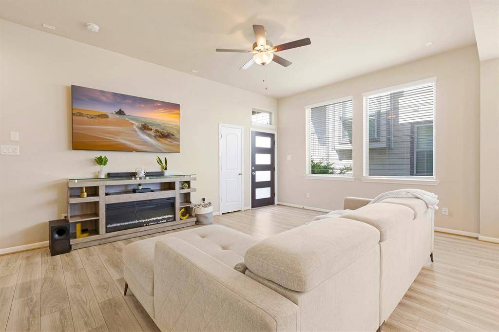 The great room has ample natural light from two windows and is finished with light tile flooring. A ceiling fan provides additional comfort.