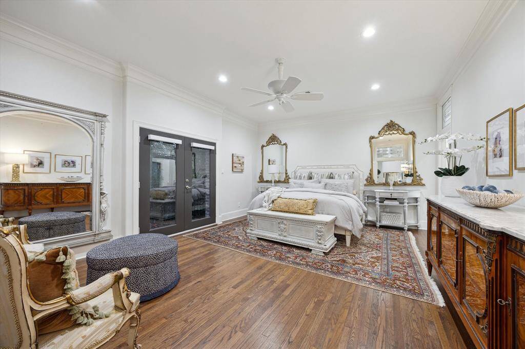 Large Primary Bedroom with wood floors, deep crown molding and a ceiling fan