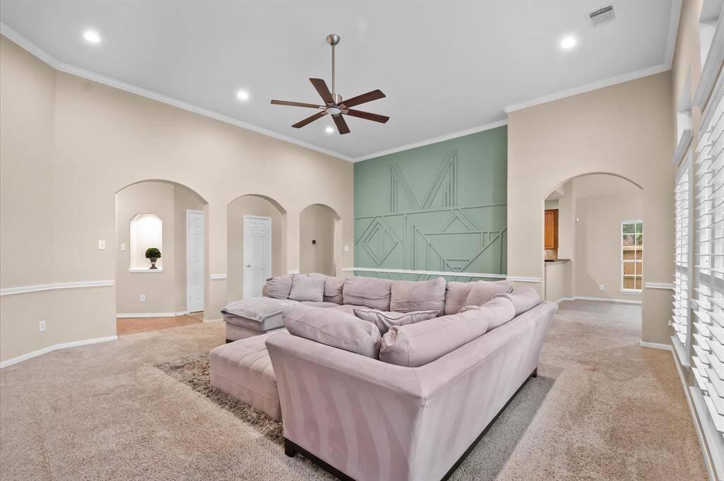 Another view of lots of space with a design wall and crown molding