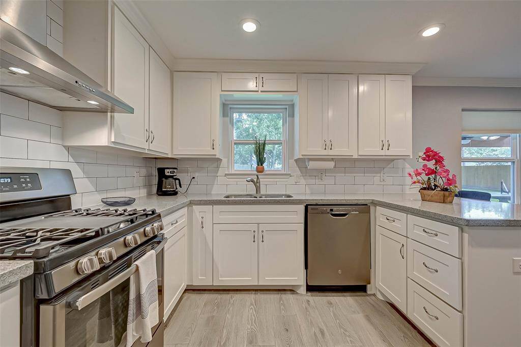 This kitchen features white cabinets, granite countertops, SS appliances, modern tile backsplash and tile floors!