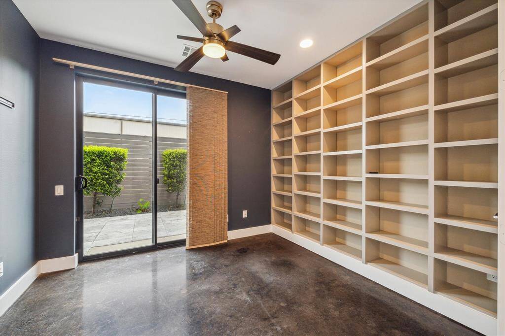 Downstairs flex room with custom built in shelving , window treatments and access to the private patio area.