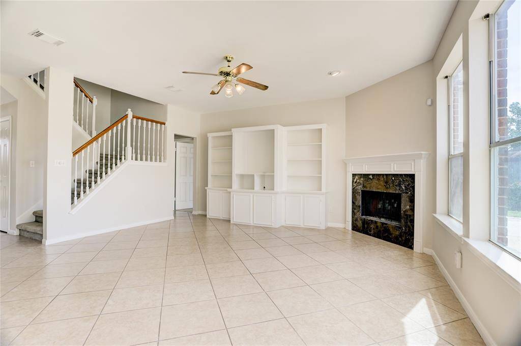 Plenty of natural light throughout the living room with built ins and a gas fireplace.