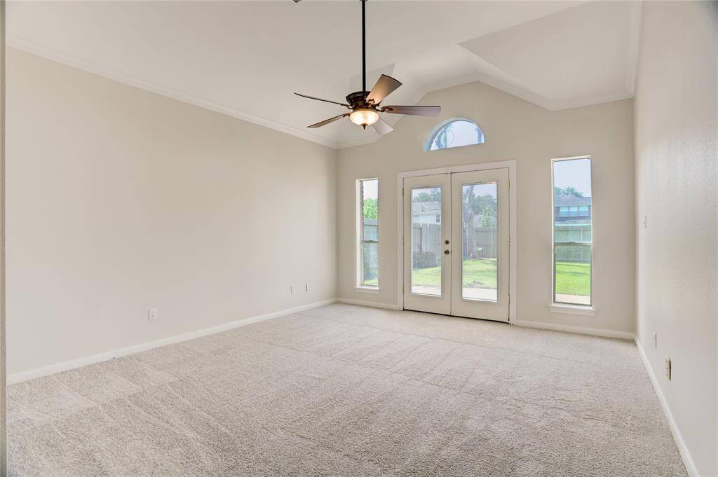 Primary bedroom has high ceilings and plenty of natural light.