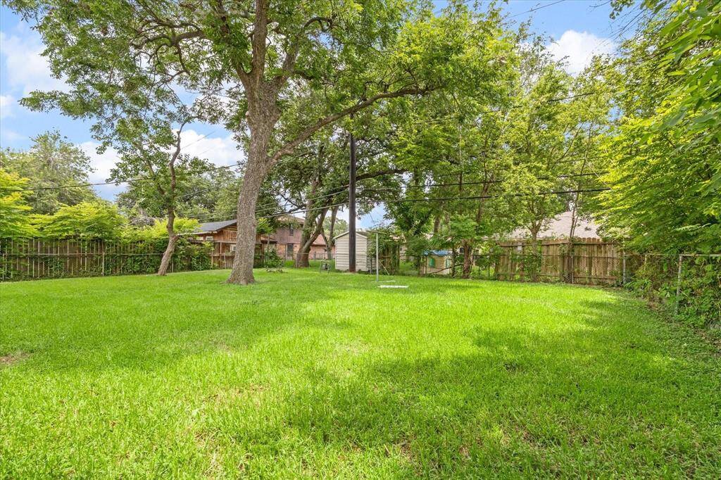 Fully fenced spacious backyard with mature trees. Offers privacy and security for outdoor enjoyment.