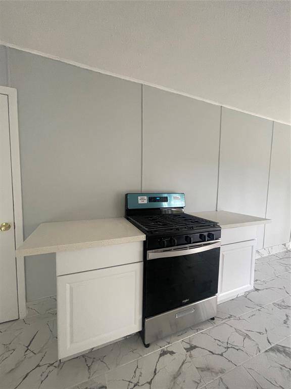 New cabinets in the kitchen with a new gas stove.