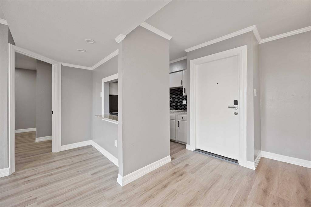 Entrance door w/ kitchen on the right, living/dining space in front, and bedrooms on each side.