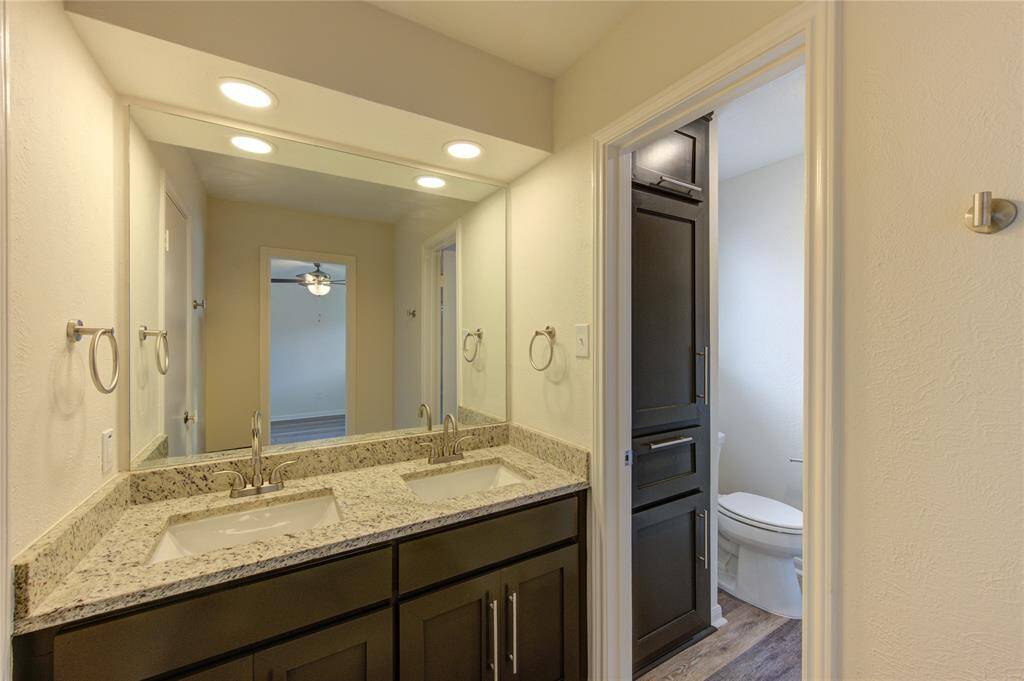 Primary Bath.  This bathroom has a new vanity cabinet with dual sinks, new granite countertop, new faucet and towel bars, new mirror and LED lighting, and all new flooring.