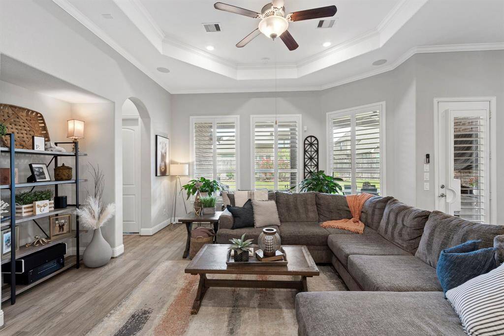 Bright living area with a wall of windows providing stunning views of the backyard, flooding the space with natural light and enchanting its modern appeal.