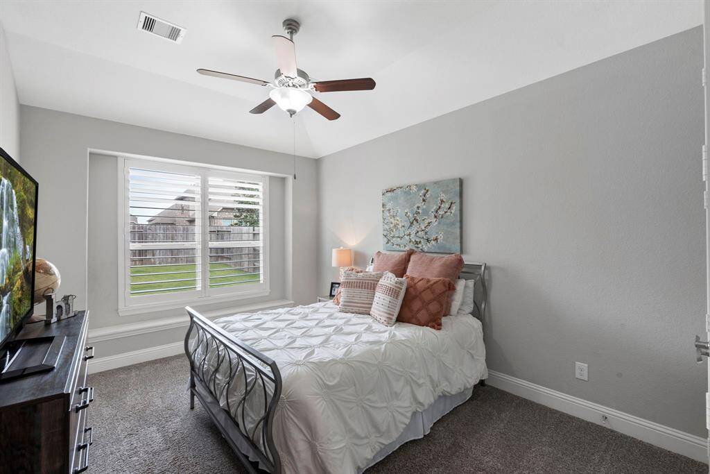 Private secondary bedroom with elegant plantation shutters. Step into this secluded secondary bedroom, where privacy meets style. Perfect space for a peaceful retreat or guest accommodations.