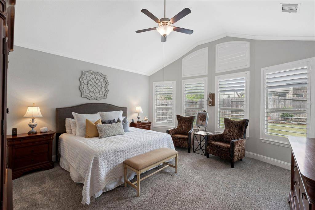 Elegant primary bedroom retreat! Escape to your private sanctuary where sophistication meets comfort. This beautifully appointed primary bedroom boasts soaring ceilings and a charming bay window that fills the space with natural light and provides a cozy seating area.