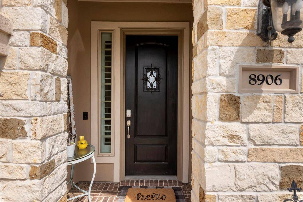 Charming stone entry with added privacy! The private front door features a unique small window at the top, allowing you to see and speak with visitors without fully opening the door-offering both convenience and security. This thoughtful feature adds an extra layer of privacy while maintaining the home's inviting charm.