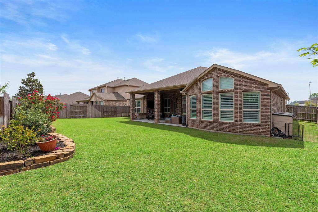 Property features a meticulously maintained backyard, offering a serene outdoor retreat. The expansive lawn is perfect for family gatherings.
