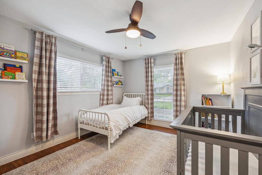 Secondary bedroom with windows looking out to the front yard and to the east side of the property.