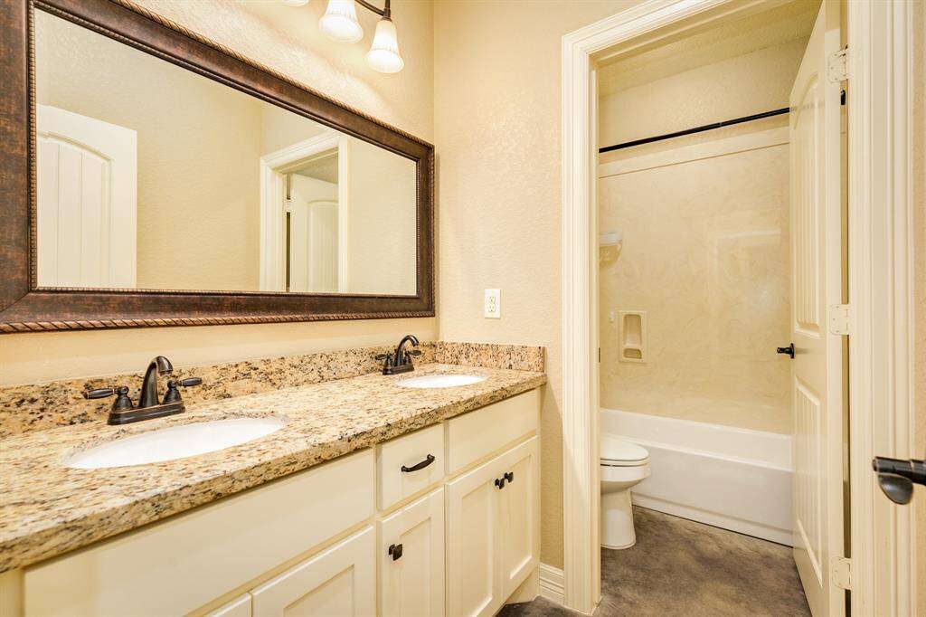Guest bathroom offers double vanities and split bathing area and wash area. This home is full of functionality.