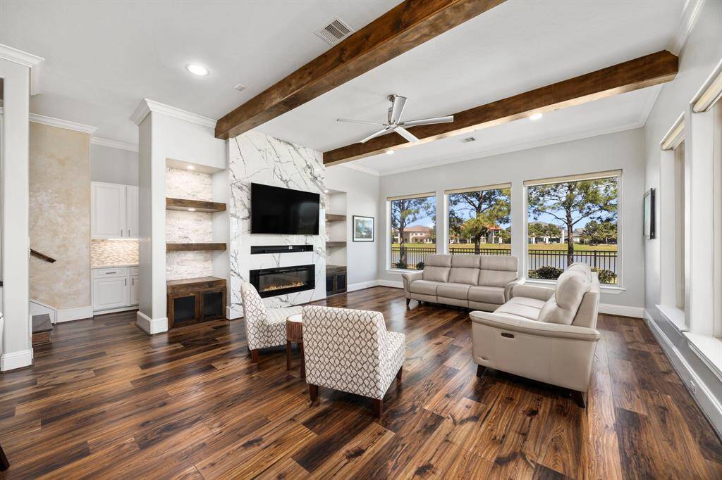 Retreat to a relaxing family room where large windows grace the walls, harmoniously blending beautiful outdoor views. A welcoming space created for spending time with family.