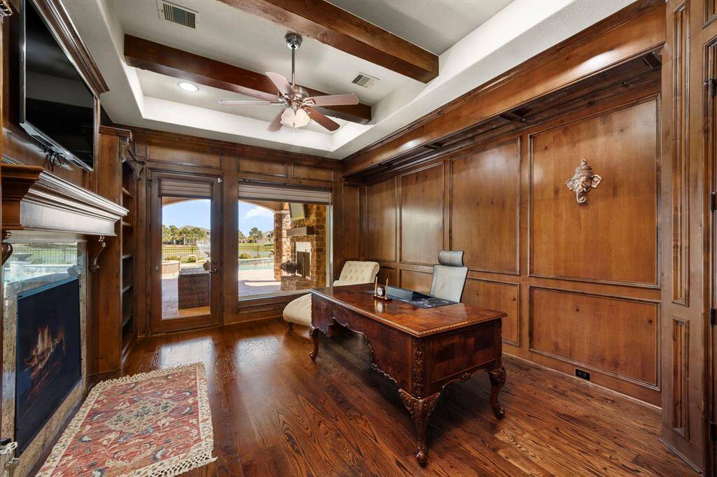 A stately & grand library curated to evoke a rich, warm ambience with custom wood paneled walls & detailed millwork.
