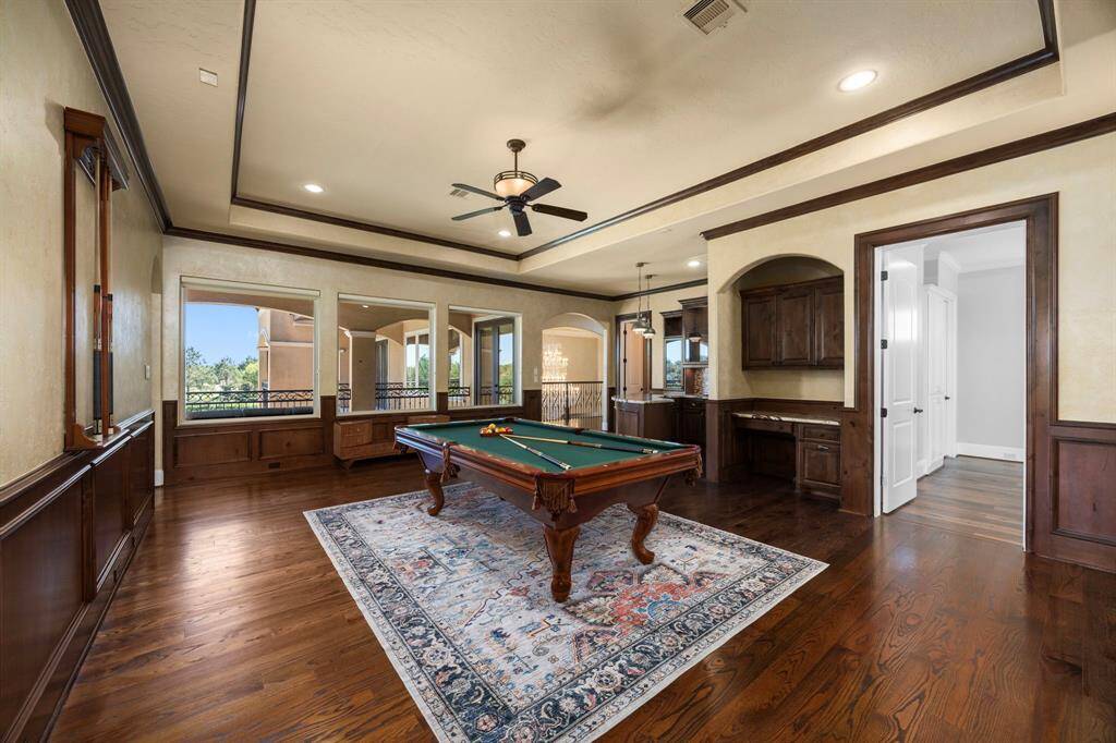 A lofty entertaining space that blends luxury with functionality.  Offering a designated wall for TV & media storage, built-in alcoves, stacked tray ceiling & large picture windows.  Step outside & indulge under the vast canopy of one of the estate’s expansive verandas that boasts serene lake views.