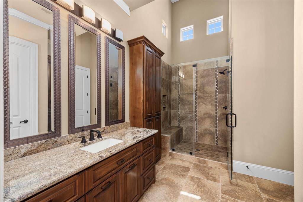 En-suite bath 3 is laden with luxury details & finishes. Frameless glass doors open to a large walk-in shower with rain shower head & seating. Grand ceilings & custom cabinetry add richness to the space. A redesigned custom closet offers built-ins & luxe amenities.