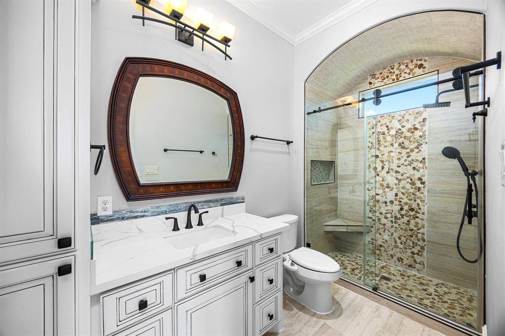En-suite bath 4 has been redesigned & offers the luxury details you expect to find. A barrel coved ceiling adorned with stone tiles creates a stunning alcove shower & frameless glass rolling doors draws your attention to the details. A custom shower would not be complete without a dual rain shower system.