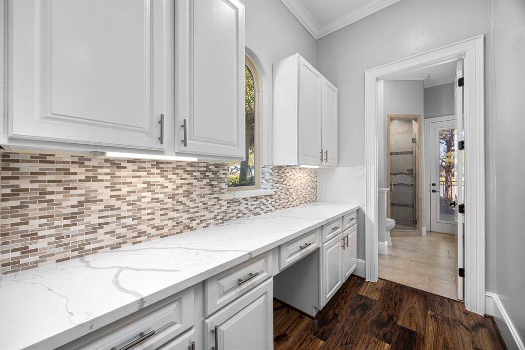 The back staircase accessed from the game room leads to this serving pantry area just off the kitchen & family room.  A full pool bath with shower & door to outside provides easy access from the pool area.
