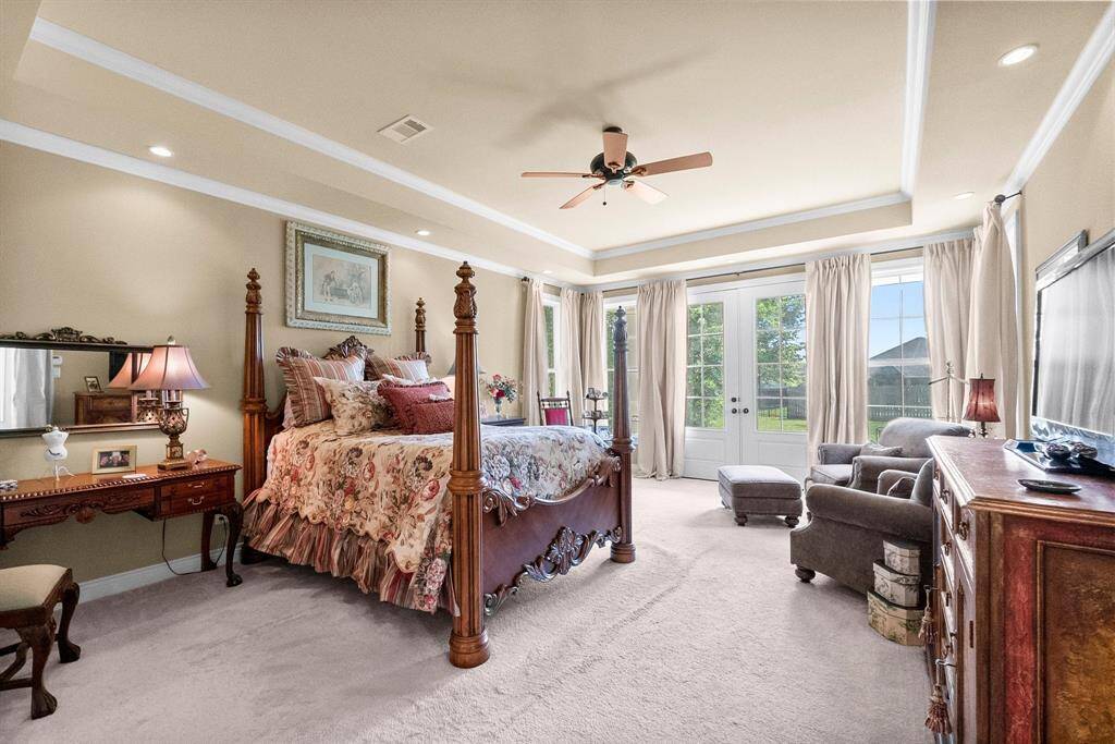 Primary bedroom with French doors to patio and backyard.