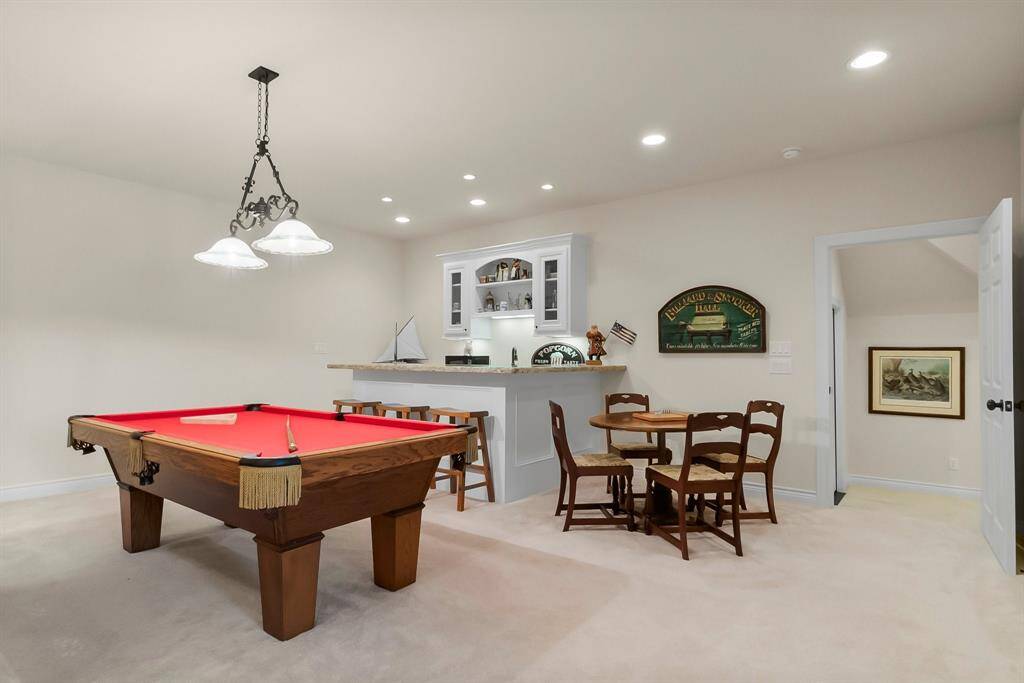 Game room with wet bar and cabinetry.