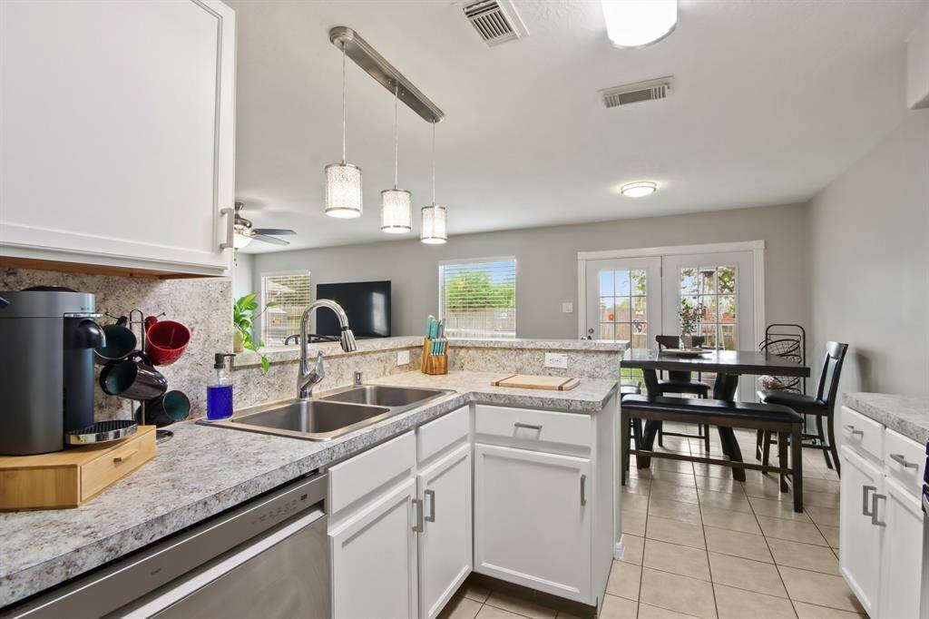 The statement pendant lights above the kitchen island, cast a warm glow over the workspace.