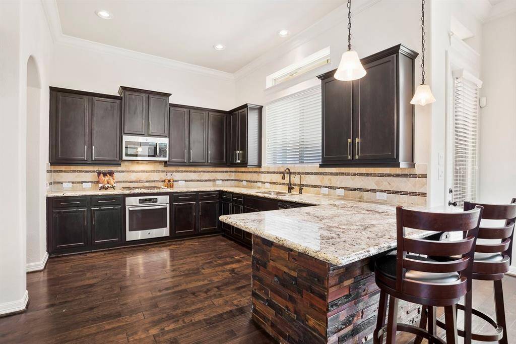 Light and bright kitchen with loads of counter space.  Notice the door to the right of the bar stools that leads you out to the covered patio.